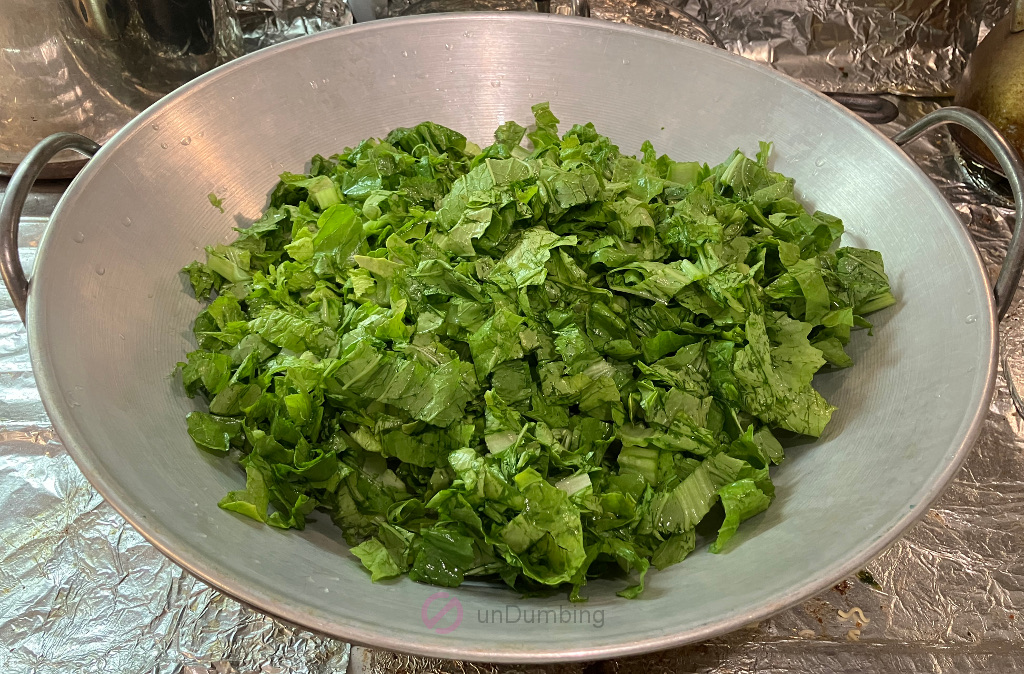 Cut Mustard Greens (Sher Li Hon) in a wok cover on a wok