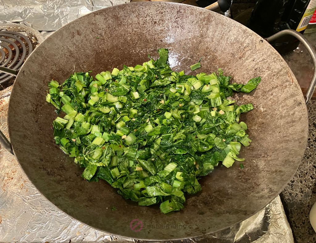 Mustard Greens (Sher Li Hon) mixed with sugar, sesame oil, and salt in the wok