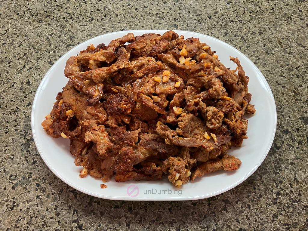 Baked Korean spicy pork on a white plate