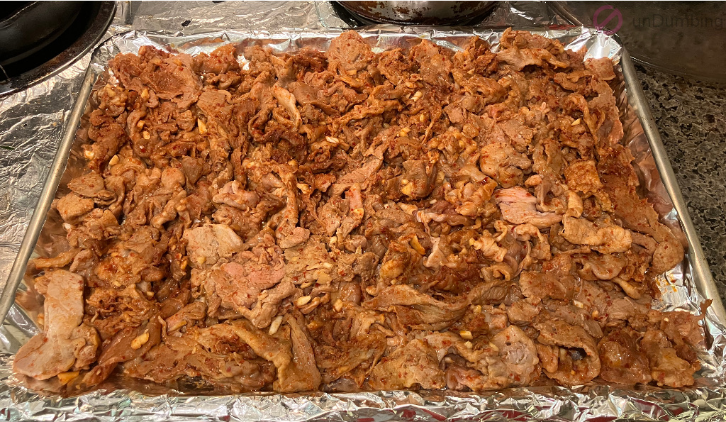 Partially cooked pork flipped and separated on the baking sheet