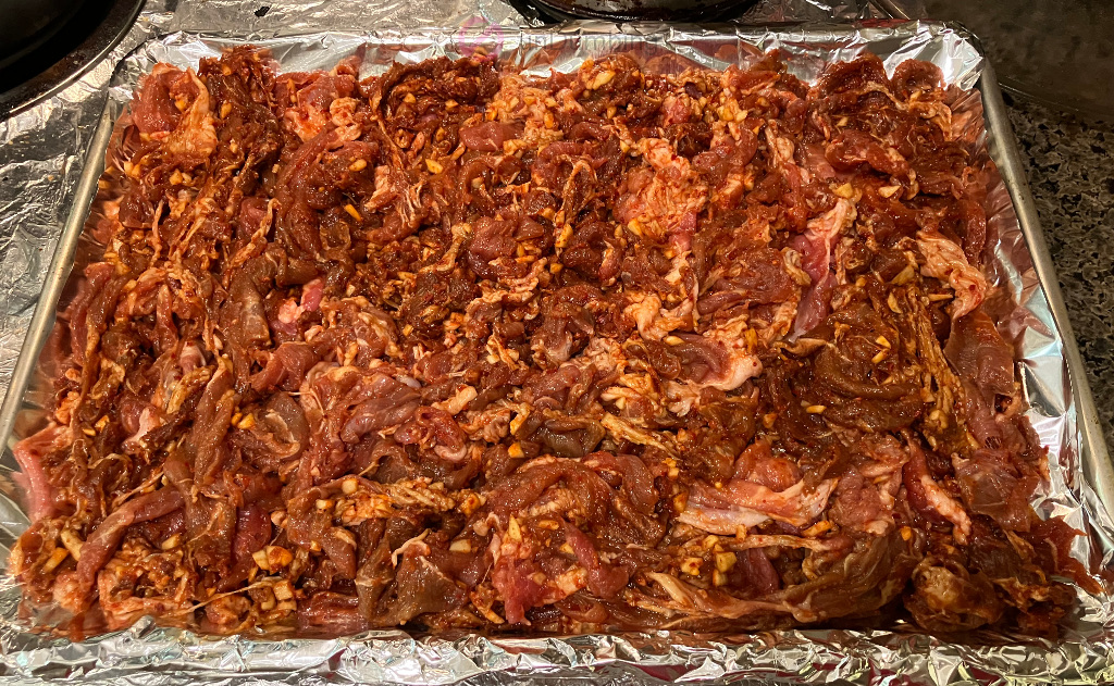 Pork slices on a foil lined baking sheet